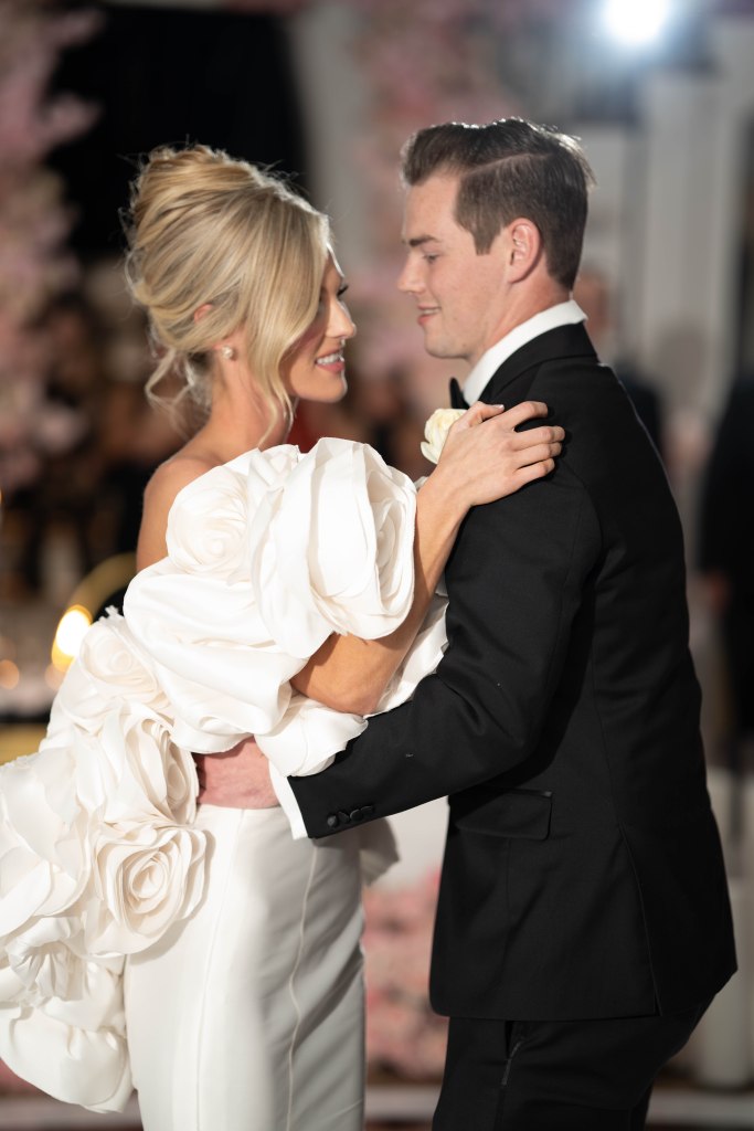 Bride and groom enjoying their romantic first dance under chandeliers
