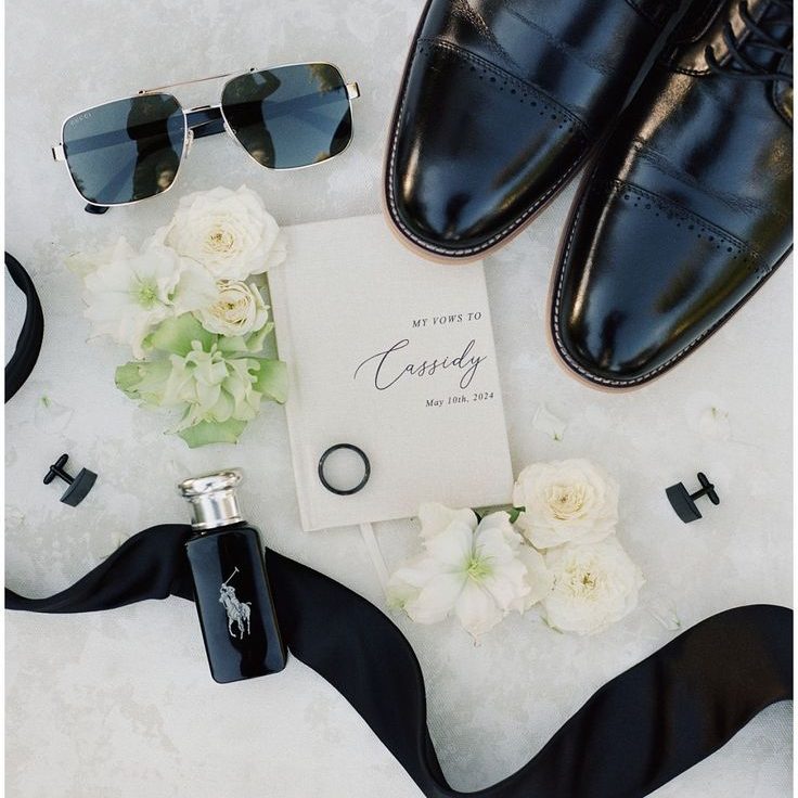 Groom's flat lay with tie, cufflinks, watch, and handwritten vows. 